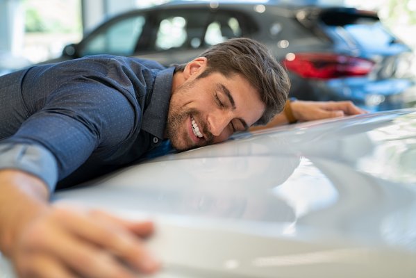 extended car warranty happy man hugging car 